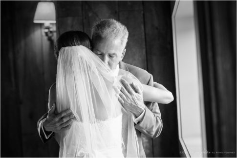 father hugs bride black and white photojournalistic moment