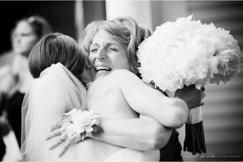 mom hugs bride black and white wedding moment