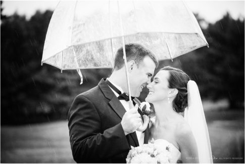 bride and groom in the rain black and white portrait