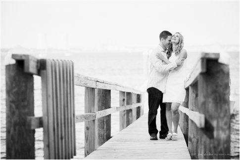 seaside engagement session bride and groom on a dock black and white image